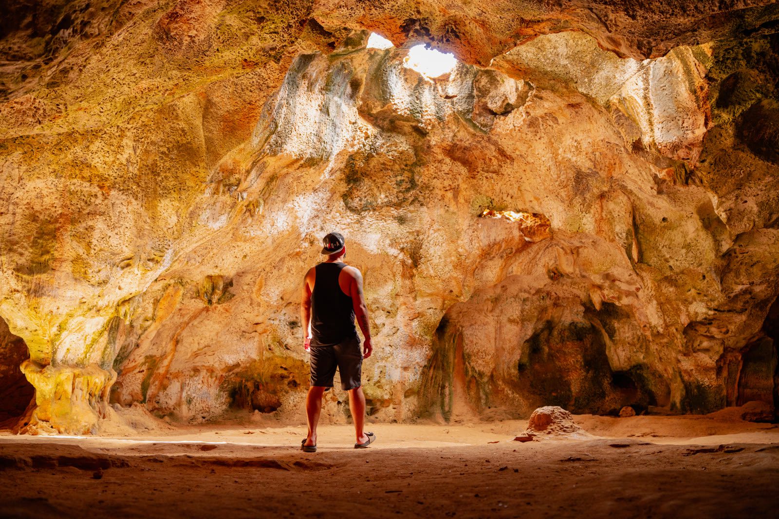 A person inside Quadirikiri cave with light through the ceiling